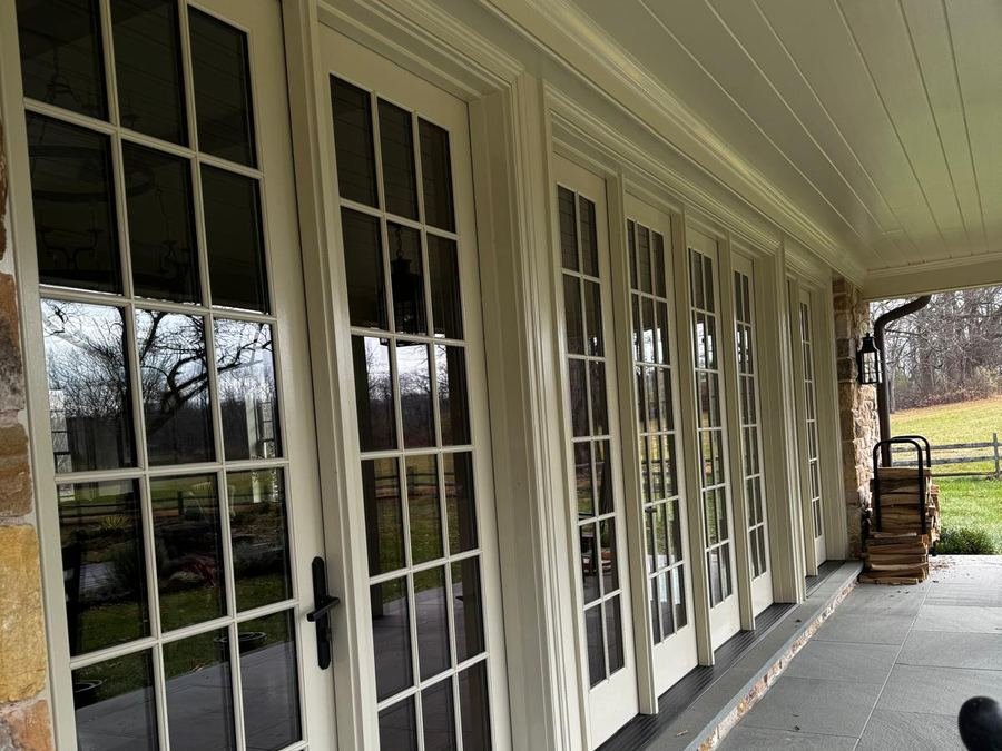 A covered porch lined with multi-pane french doors