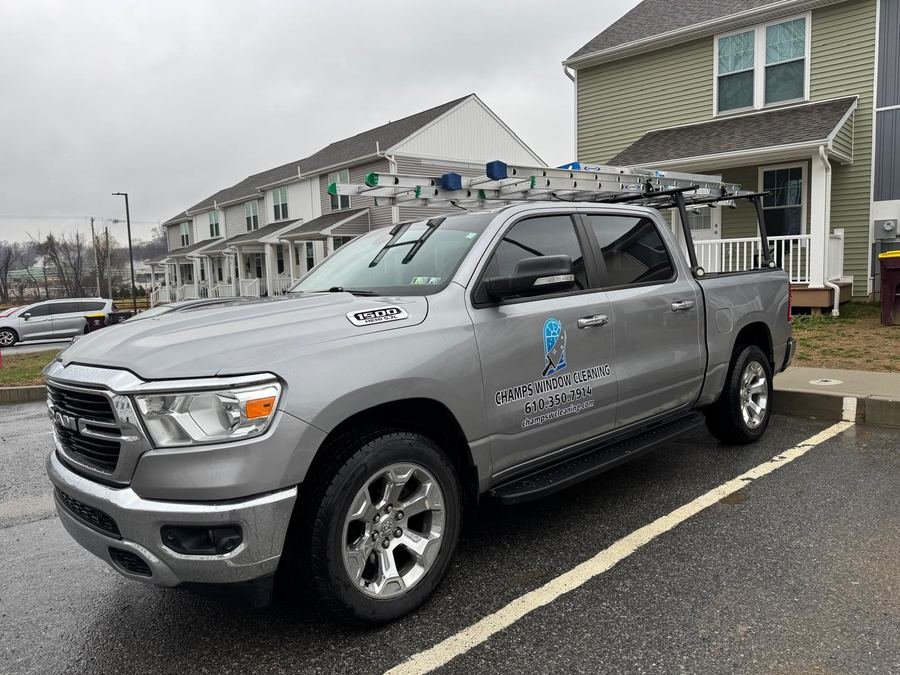 The Champs Window Cleaning truck parked at a job site